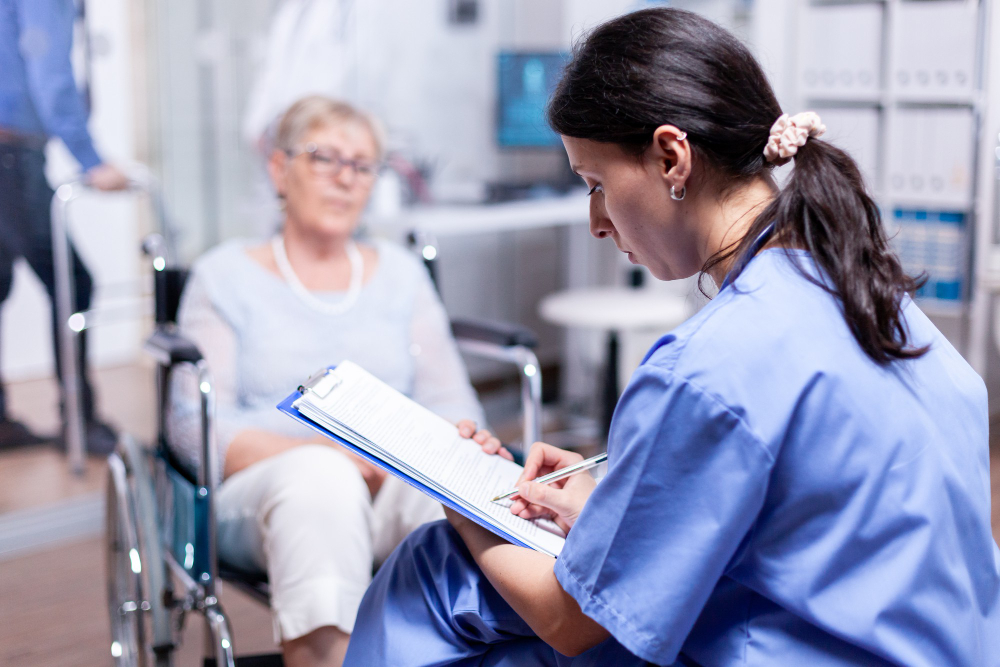 nurse writing prescription disabled senior woman wheelchair after medical examination